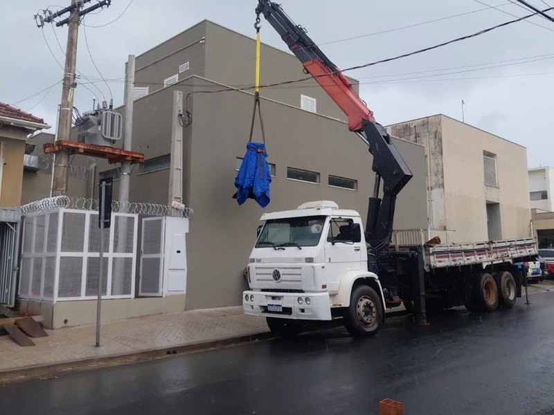Caminhão Munck içando carga em rua urbana